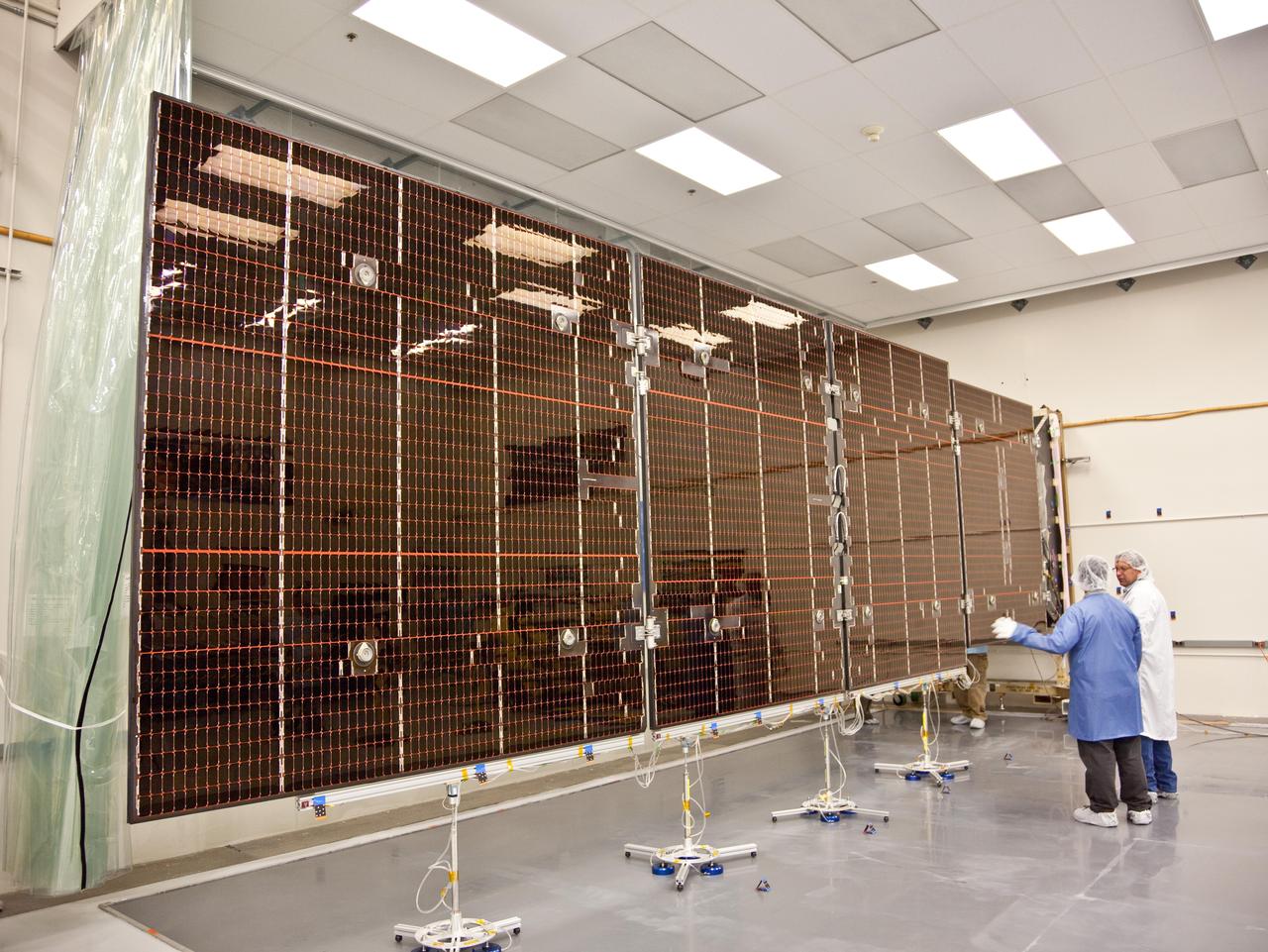 Technicians test the deployment of one of the three massive solar arrays that power NASA Juno spacecraft.