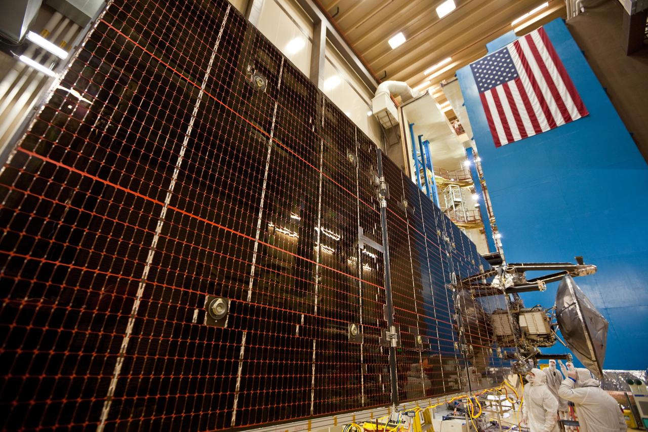 Technicians test the deployment of one of the three massive solar arrays that power NASA Juno spacecraft.