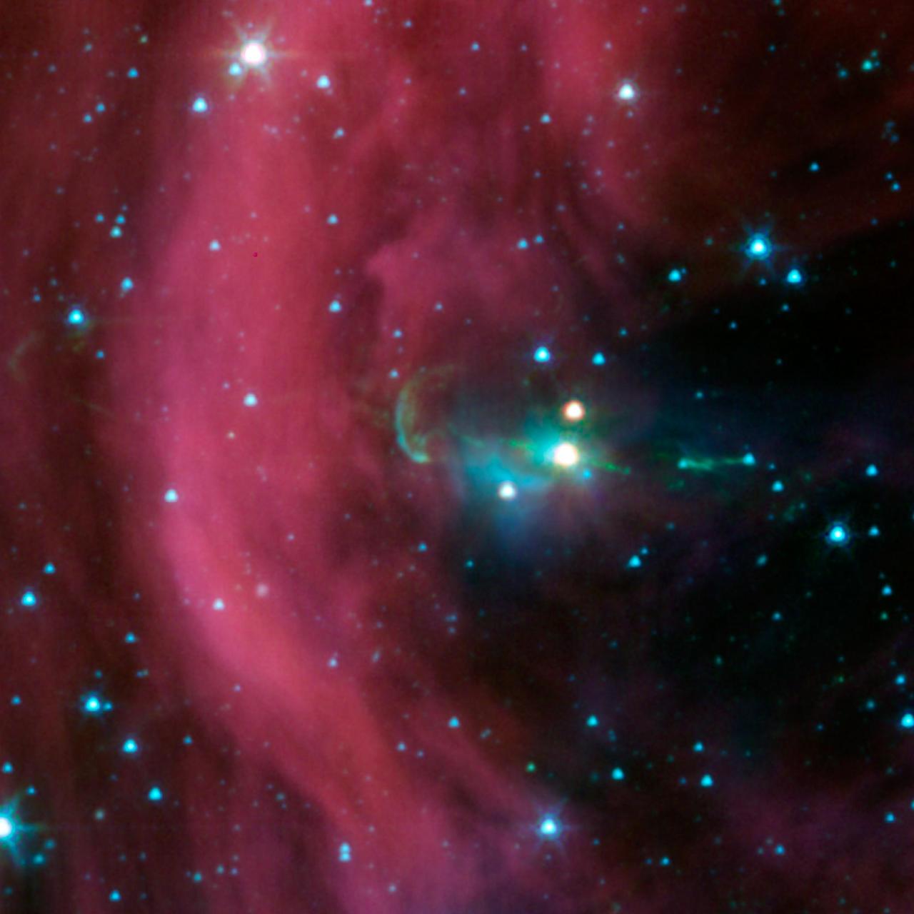 NASA Spitzer Space Telescope took this image of a baby star sprouting two identical jets green lines emanating from fuzzy star. The left jet was hidden behind a dark cloud, which Spitzer can see through.