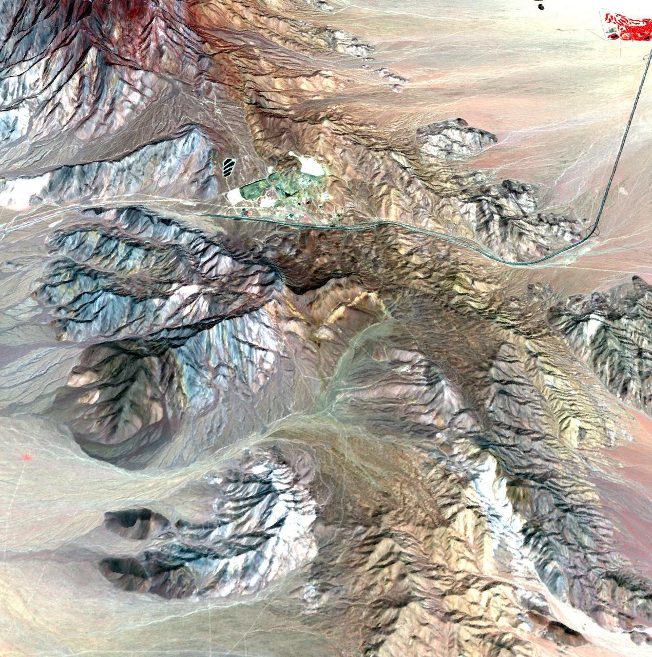 This image of the Mountain Pass rare open-pit earth mine was acquired by NASA Terra spacecraft in southeastern California near the Nevada border.