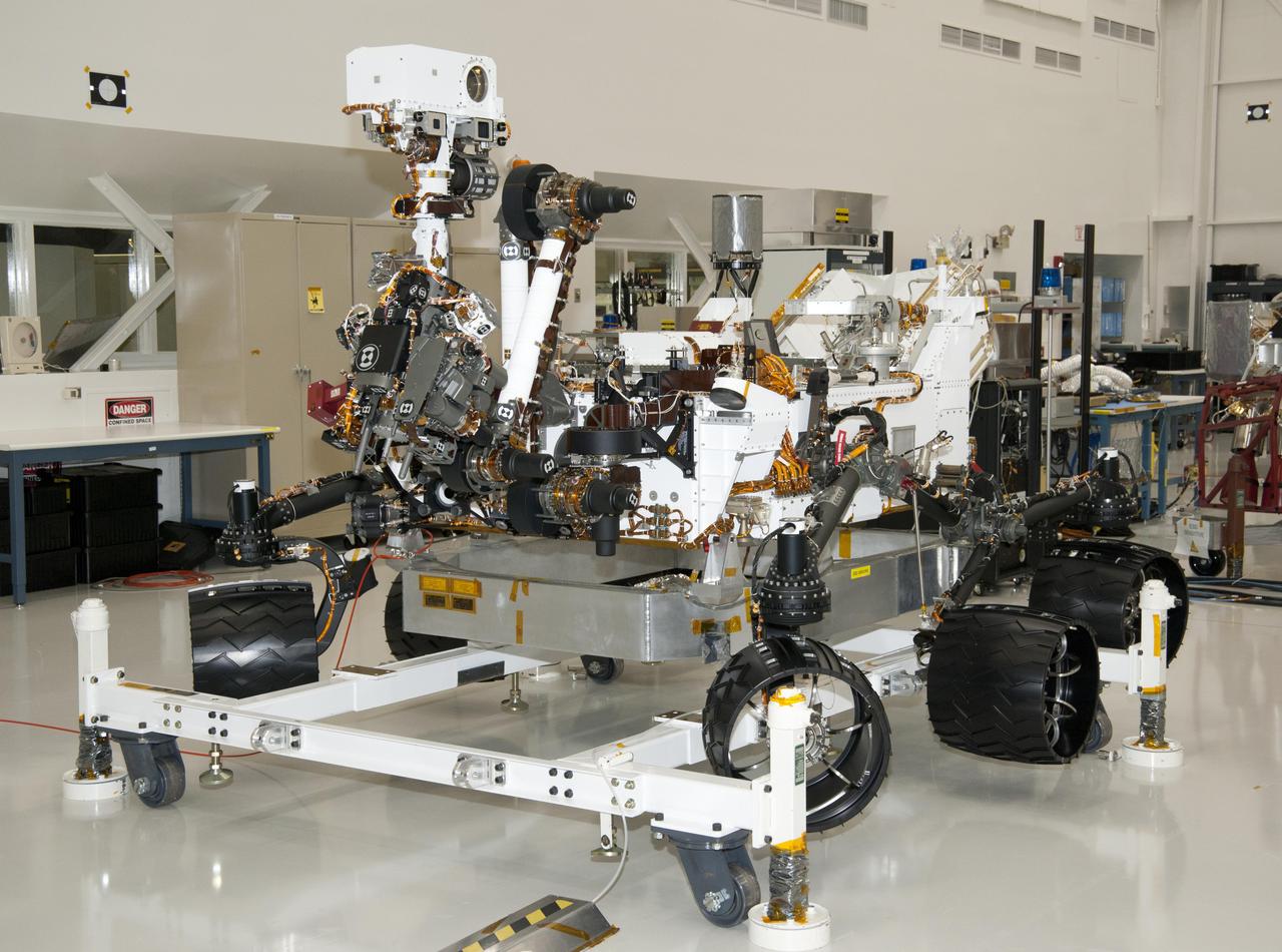 The rover for NASA Mars Science Laboratory mission, named Curiosity, is seen here inside the Spacecraft Assembly Facility at NASA Jet Propulsion Laboratory, Pasadena, Calif. Support equipment is holding the rover slightly off the floor.