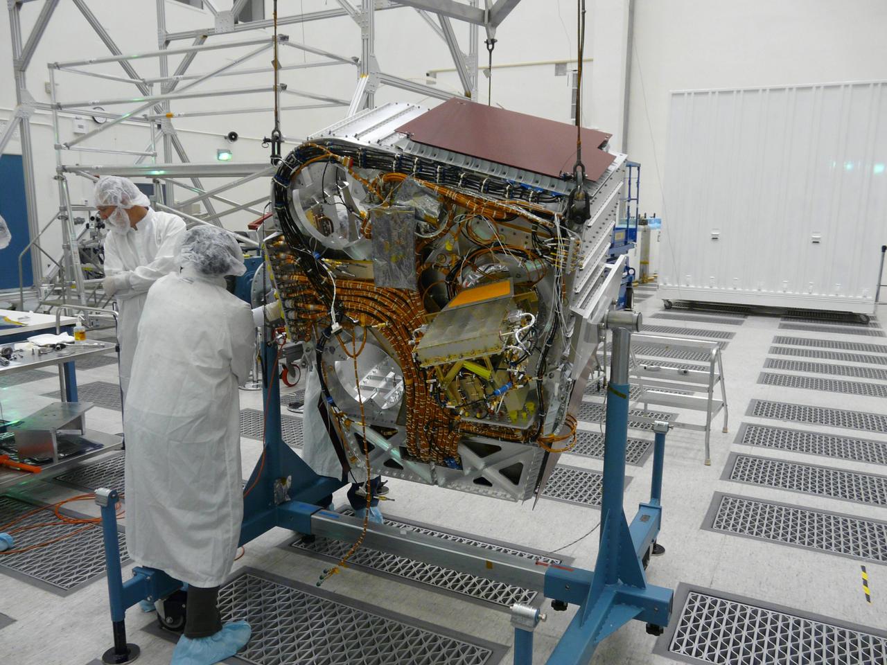 Engineers check cables on back of Aquarius instrument in the clean room at NASA Jet Propulsion Laboratory in Pasadena, Calif.