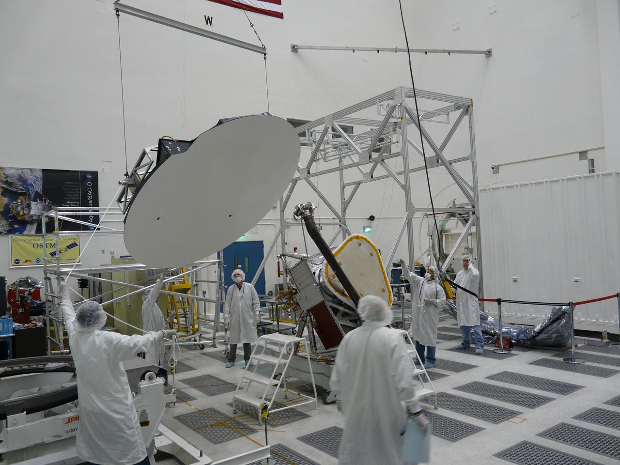 Aquarius 2.5 meter reflector is hoisted before being attached to boom in the clean room at NASA Jet Propulsion Laboratory in Pasadena, Calif.