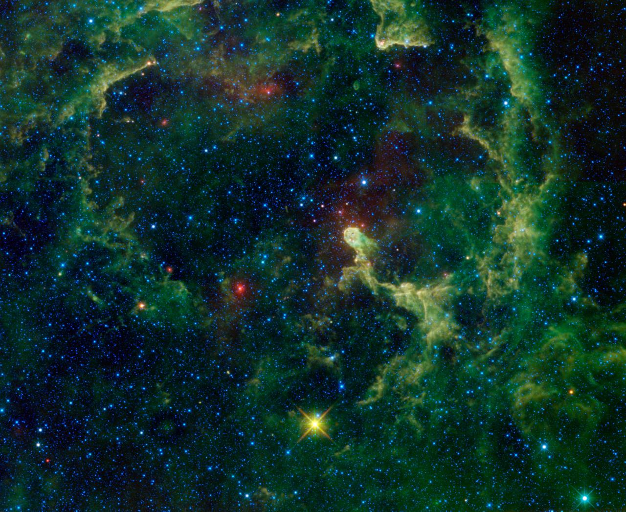 This image of the Elephant Trunk nebula from NASA Wide-field Survey Explorer shows clouds of dust and gas being pushed and eroded by a massive star. The bright trunk of the nebula near the center is an especially dense cloud.