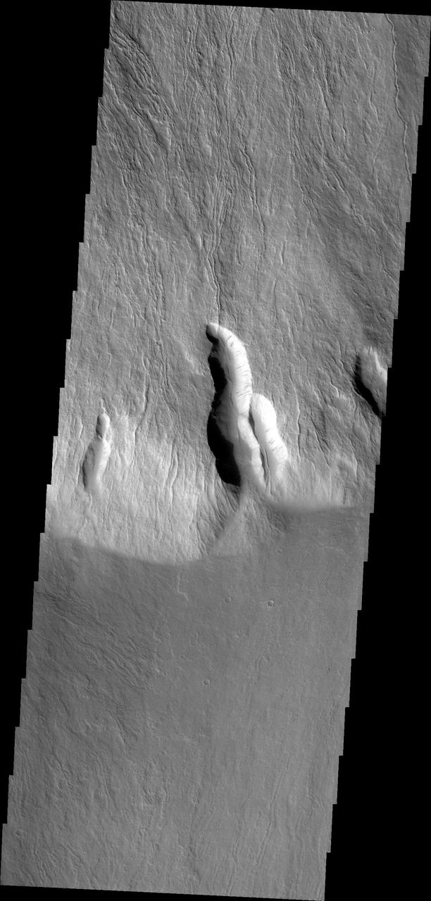 This image captured by NASA 2001 Mars Odyssey shows lava flows in the southern escarpment region of Olympus Mons, the largest known volcano in the solar system.