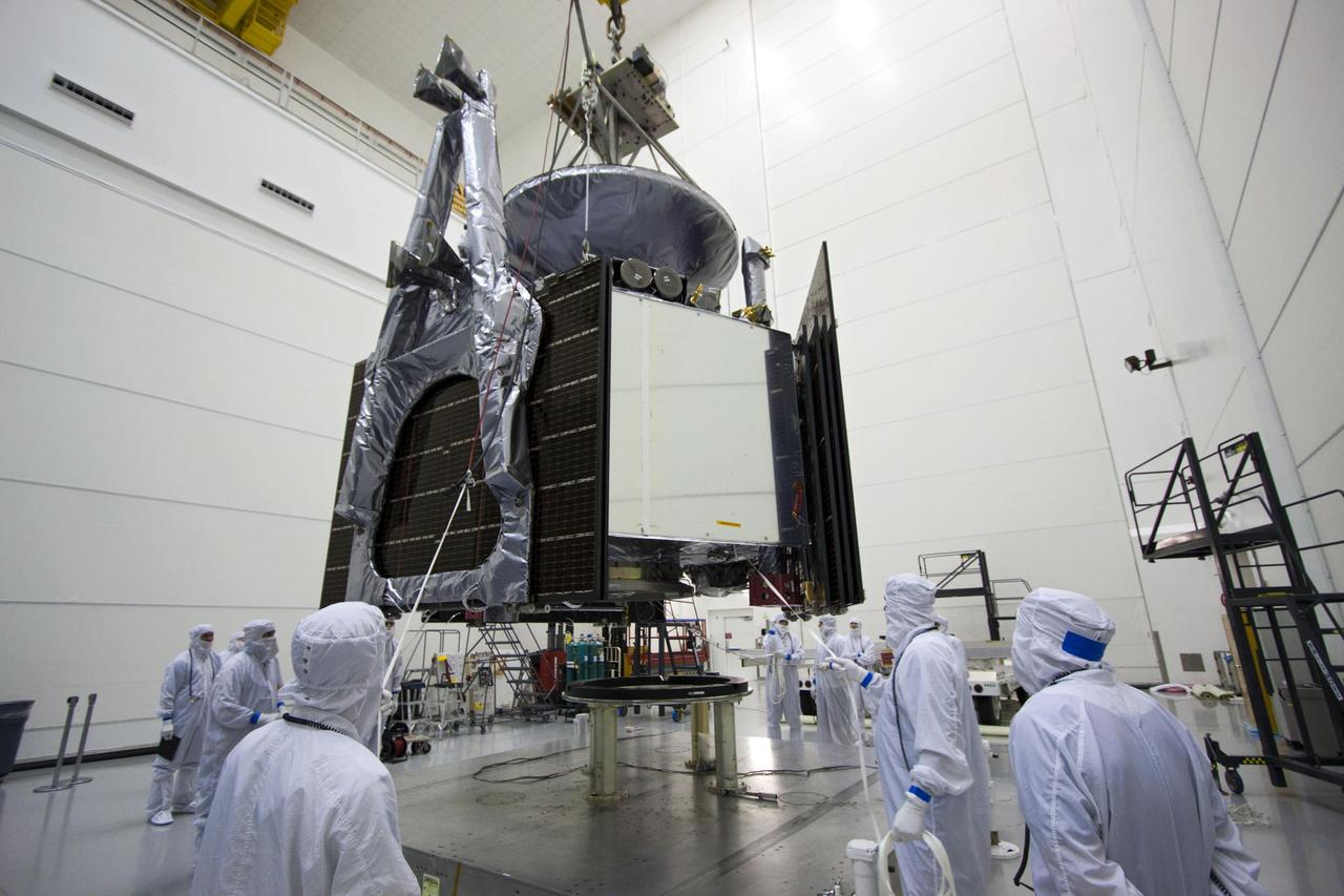 Technicians use an overhead crane to lower NASA Juno spacecraft onto a fueling stand where the spacecraft will be loaded with the propellant necessary for its mission to Jupiter.