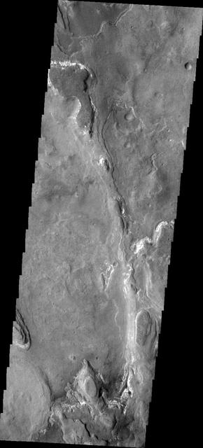 The layered ridge and mesas in this image from NASA 2001 Mars Odyssey spacecraft are located on the northern margin of Hellas Basin.