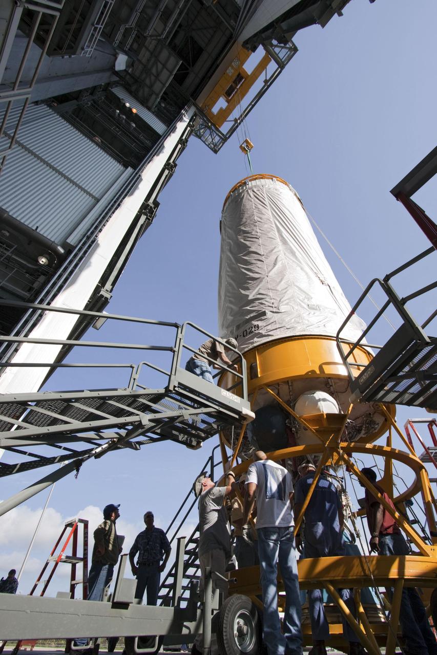 Workers guide an overhead crane as it lifts the Centaur upper stage at the Cape Canaveral Air Force Station, Fla., June 24, 2011. The Centaur is slated to launch NASA Juno spacecraft on August 5.