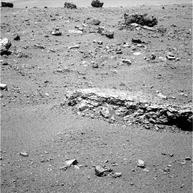 The flat-topped rock, informally named Tisdale 2, just below the center of this raw image from the rover Opportunity panoramic camera was chosen by the rover team in August 2011 as a stop for inspecting with tools on Opportunity robotic arm.