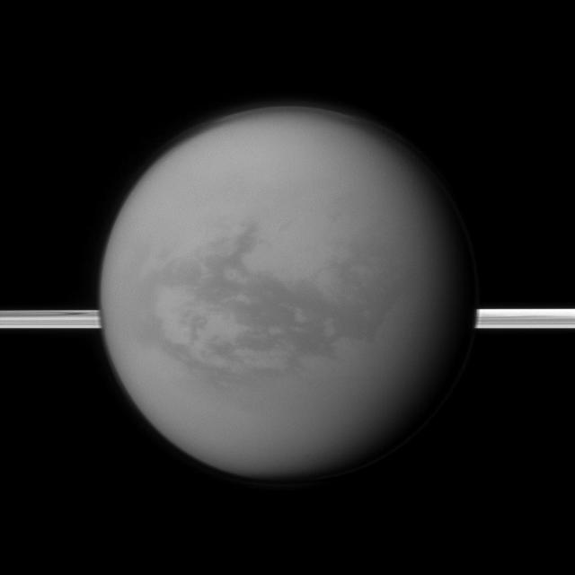 Saturn rings lie in the distance as NASA Cassini spacecraft looks toward Titan and its dark region called Shangri-La, east of the landing site of the Huygens Probe.
