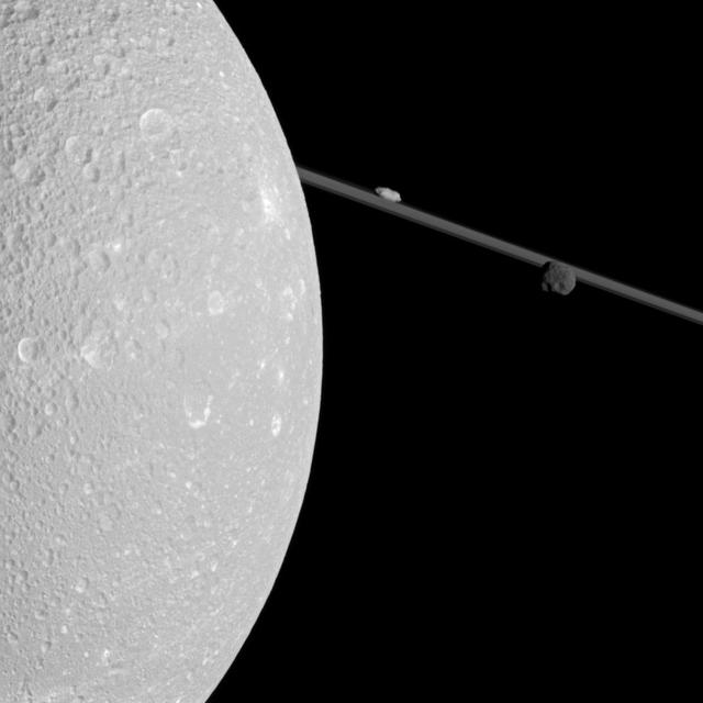 Flying past Saturn moon Dione, NASA Cassini captured this view which includes two smaller moons, Epimetheus and Prometheus, near the planet rings.