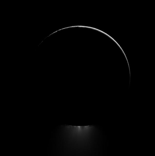 Below a darkened Enceladus, a plume of water ice is backlit in this view of one of Saturn most dramatic moons. This image was captured by NASA Cassini spacecraft.