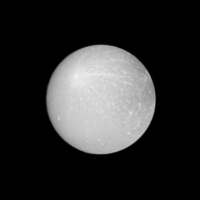 NASA Cassini spacecraft looks at an example of a ray crater on the leading hemisphere of Saturn moon Dione. The ray crater is in the upper-left of the image and ejecta rays show up as brighter material emanating from the crater.