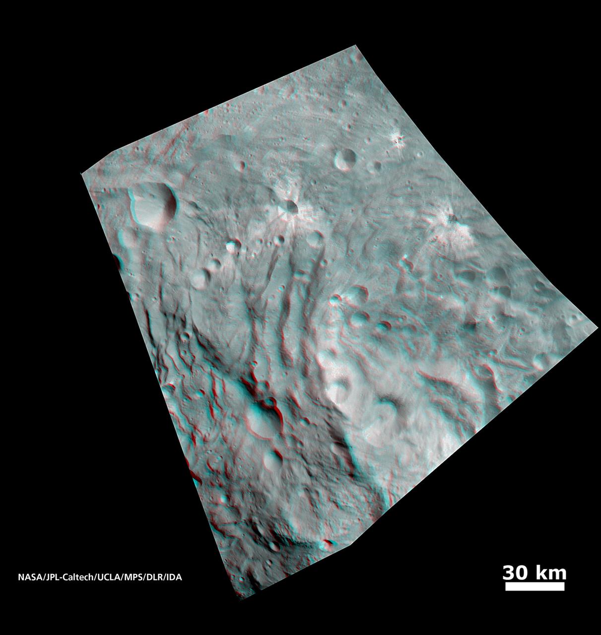 In this image, obtained by NASA Dawn spacecraft from above the surface of the giant asteroid Vesta, topography in the area surrounding the south pole area shows impact craters, ridges and grooves. You need 3D glasses to view this image.