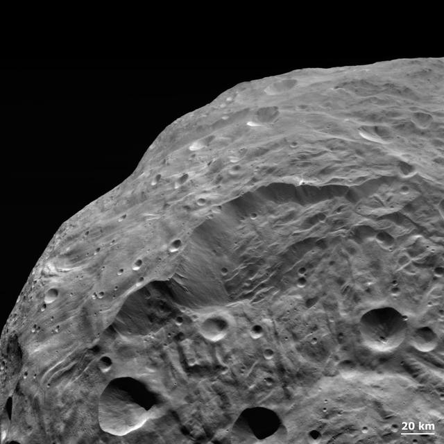 NASA Dawn spacecraft obtained this image of the giant asteroid Vesta with its framing camera on Aug. 26, 2011. The detail in this image shows a steep scarp with landslides and vertical craters in the scarp wall. 