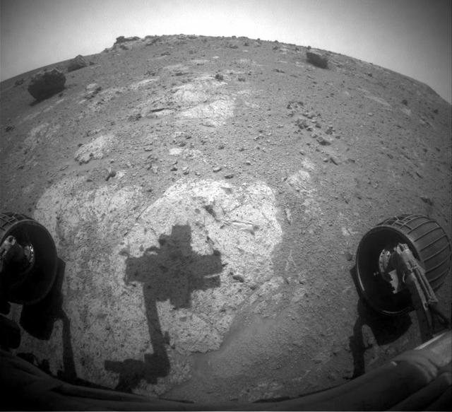 The robotic arm of NASA Mars Exploration Rover Opportunity casts a shadow on a rock outcrop called Chester Lake. The rock is on a low ridge called Cape York, which is a segment of the western rim of Endeavour crater.