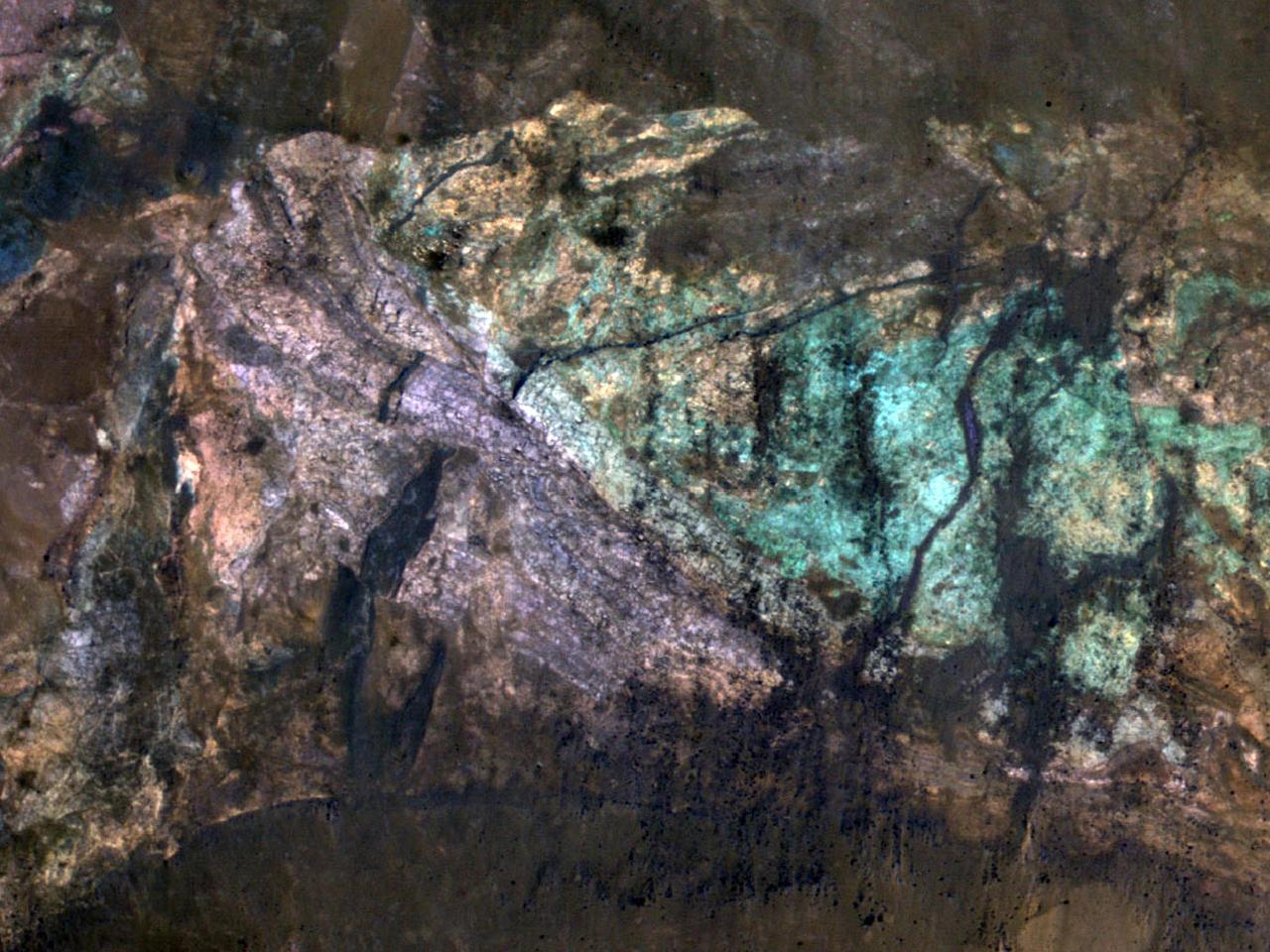 The colorful rocks exposed in the central peak visible in this image from NASA Mars Reconnaissance Orbiter probably reflect variations in mineral content that were caused by water activity early in Mars history.