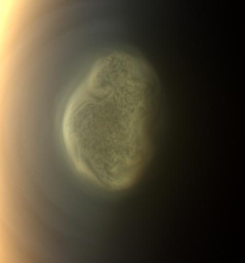 This true color image captured by NASAS Cassini spacecraft before a distant flyby of Saturn moon Titan on June 27, 2012, shows a south polar vortex, or a mass of fluid-like clouds and haze swirling around the pole in the atmosphere of the moon.