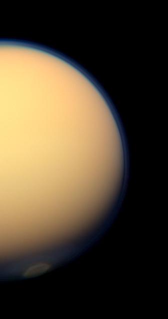 The recently formed south polar vortex stands out in the color-swaddled atmosphere of Saturn largest moon, Titan, in this natural color view from NASA Cassini spacecraft.