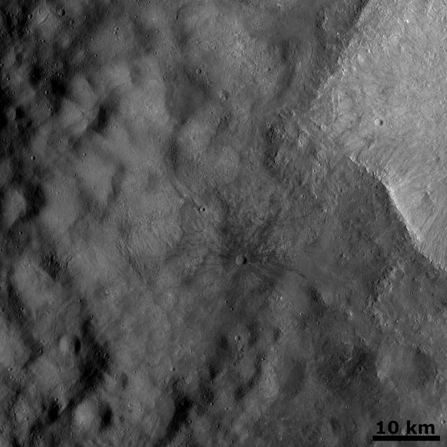 The crater on asteroid Vesta shown in this image from NASA Dawn spacecraft was emplaced onto the ejecta blanket of two large twin craters. Commonly, rays from impact craters are brighter than the surrounding surface.