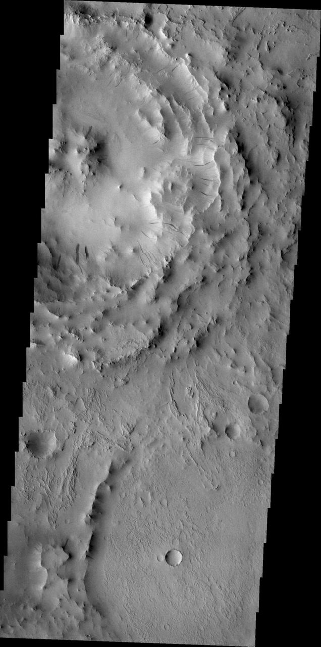 Dark slope streaks are visible on the rim of this unnamed crater located on the floor of Cassini Crater in this image from NASA 2001 Mars Odyssey spacecraft.