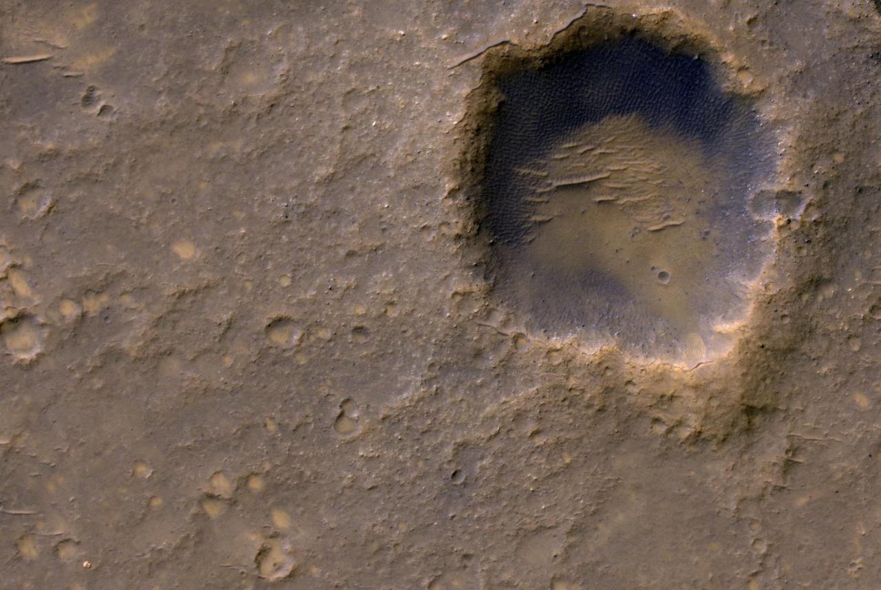 Near the lower left corner of this view is the three-petal lander platform that NASA Mars Exploration Rover Spirit drove off in January 2004. The lander is still bright, but with a reddish color, probably due to accumulation of Martian dust.