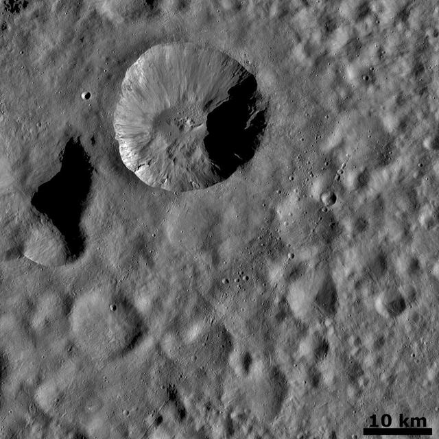 This image from NASA Dawn spacecraft is dominated by a wide, young, fresh crater on asteroid Vesta. Surrounding this crater is its ejecta blanket, a covering of small particles that were thrown out during the impact that formed the crater.