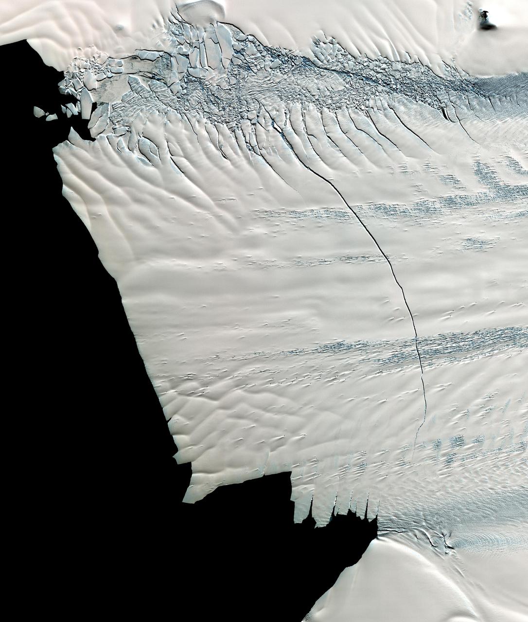 This image from NASA Terra spacecraft shows a massive crack across the Pine Island Glacier, a major ice stream that drains the West Antarctic Ice Sheet. Eventually, the crack will extend all the way across the glacier.
