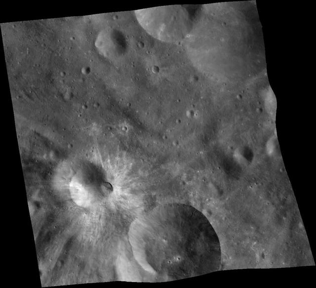 This mosaic of three images was taken by NASA Dawn framing camera during the high-altitude mapping orbit over the giant asteroid Vesta. The eastern rim is higher than the western rim, and the overall topography is downhill from east to west.