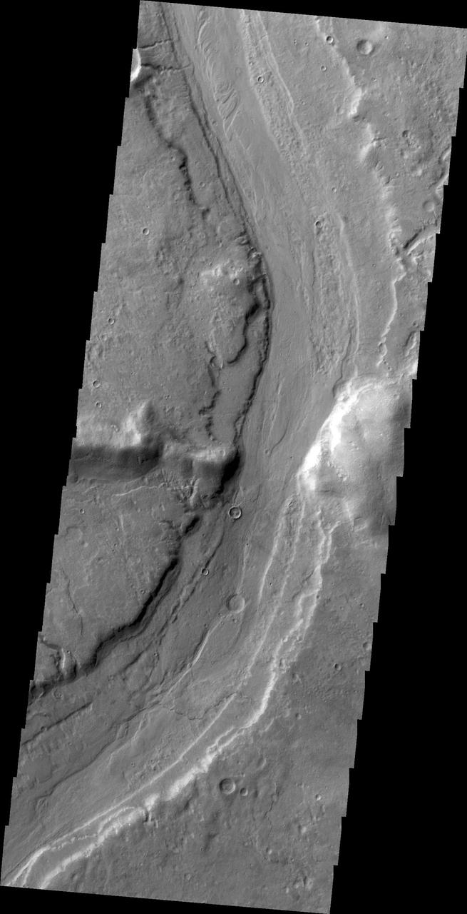 This image captured by NASA 2001 Mars Odyssey spacecraft shows Reull Vallis where it cuts through the rim of Lipik Crater.