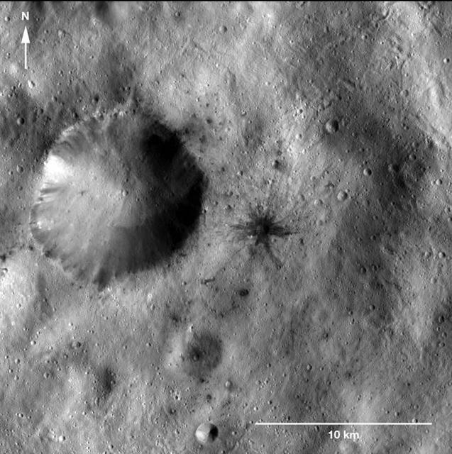 This image of a dark-rayed impact crater and several dark spots was obtained by NASA Dawn spacecraft. The dark materials are located near an older, larger crater in the Sextilia quadrangle of asteroid Vesta southern hemisphere.