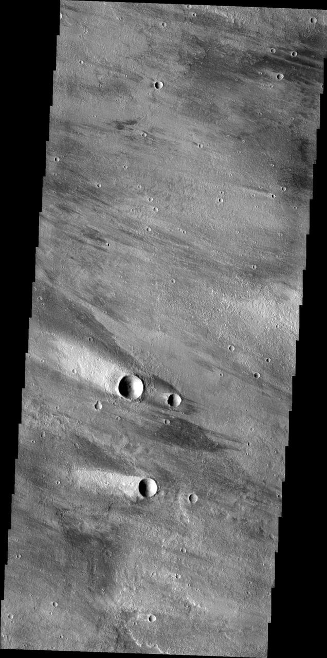The windstreaks in this image captured by NASA 2001 Mars Odyssey spacecraft are located on the volcanic plains northeast of Olympus Mons.