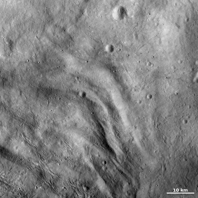 This image from NASA Dawn spacecraft shows undulating terrain, located only in asteroid Vesta southern hemisphere, in and around the Rheasilvia impact basin.