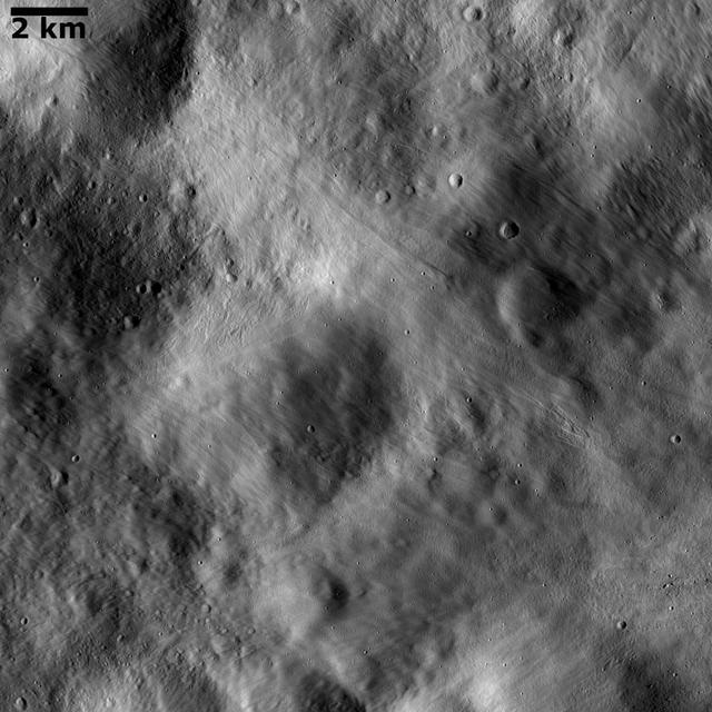 This image from NASA Dawn spacecraft shows impact ejecta deposits dominating asteroid Vesta landscape. This impact ejecta material was ejected from an impact crater located outside the imaged area.