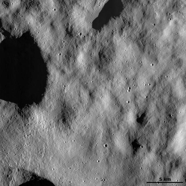 This image from NASA Dawn spacecraft shows a relatively smooth part of asteroid Vesta surface. This smooth texture is probably due to the surface being covered in a layer of tiny dust particles.