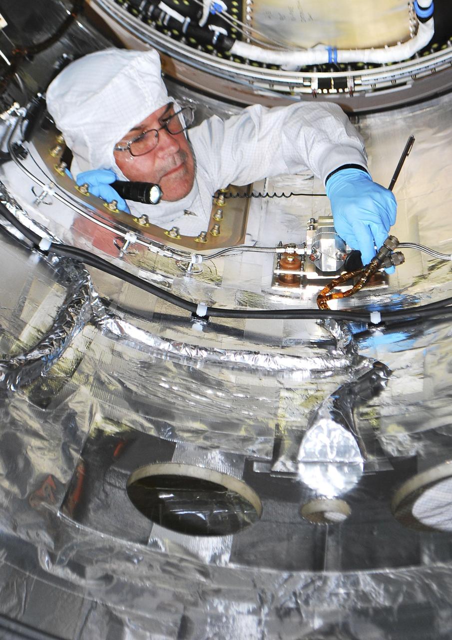 A spacecraft technician is performing closeout work inside the fairing that will be installed around NASA Nuclear Spectroscopic Telescope Array NuSTAR spacecraft in a processing facility at Vandenberg Air Force Base in California.