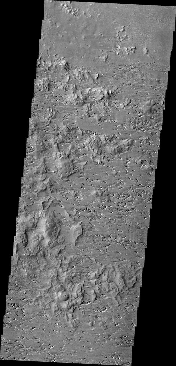 This image captured by NASA 2001 Mars Odyssey spacecraft shows the complexity of wind erosion on Mars. The erosion of the hills and the gouge-like pits indicate two, if not three wind directions that all altered the surface.