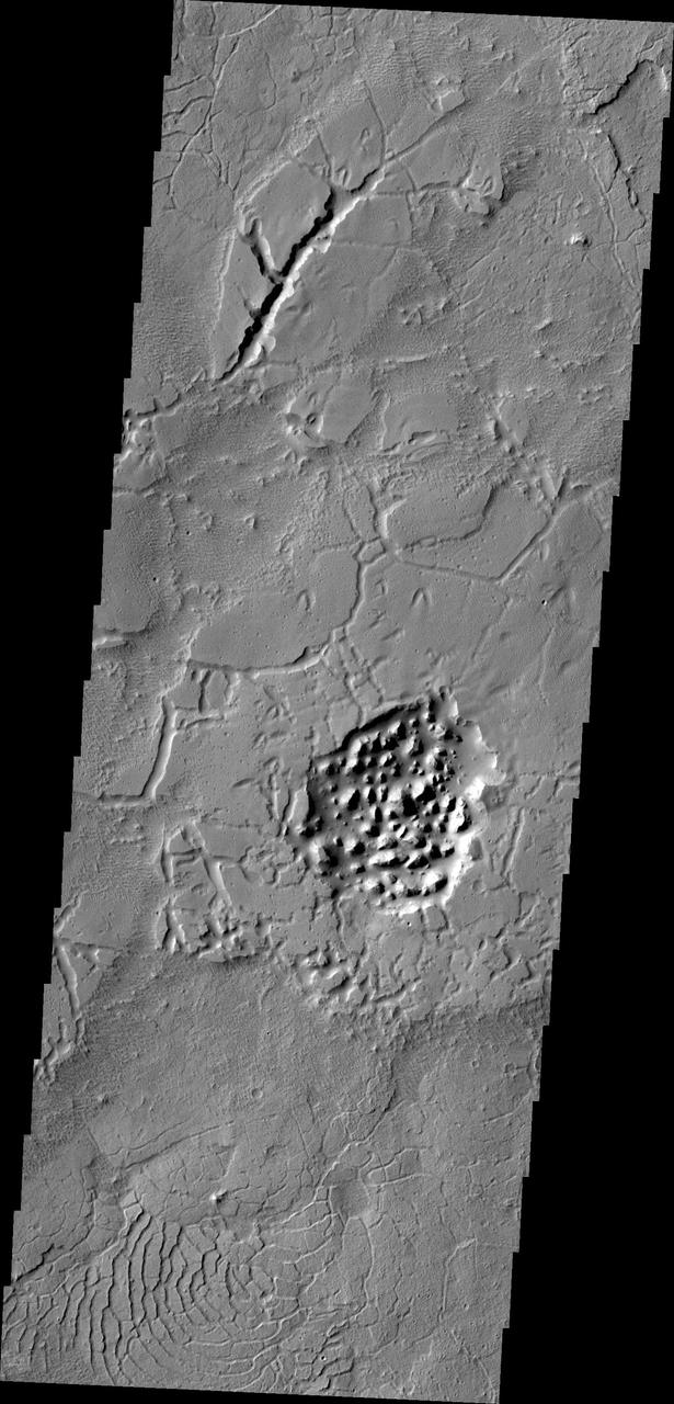 The Avernus region contains several different surface features. These include tectonic fractures, ridges, hills, and regions of chaos within isolated depressions termed cavi. This image was captured by NASA 2001 Mars Odyssey spacecraft.