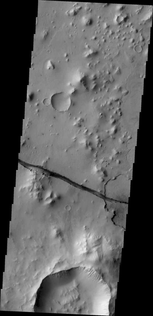 The fracture is this image captured by NASA 2001 Mars Odyssey spacecraft cuts right through a hill, indicating tremendous tectonic stresses were at work to create this feature.