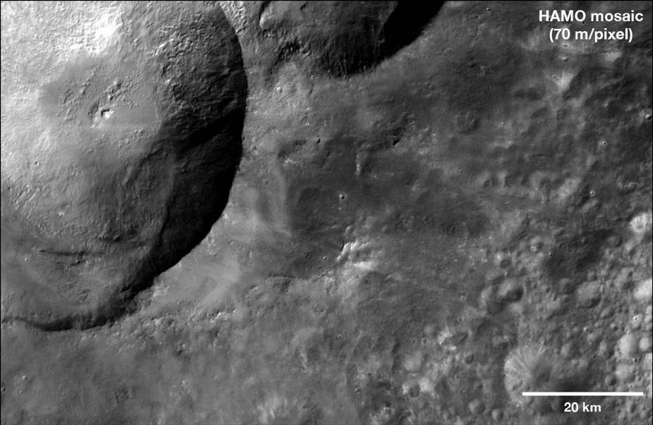 This mosaic from NASA Dawn spacecraft shows dark material near a series of craters known as the nowman on asteroid Vesta. That ejected material is a complex mixture of components.
