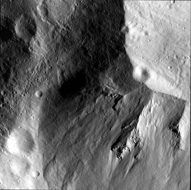 This image from NASA Dawn spacecraft shows a close-up view of the wall of the Rheasilvia impact basin on asteroid Vesta.
