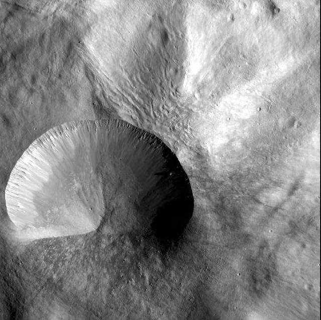 This image from NASA Dawn spacecraft shows a young crater on asteroid Vesta. Layering is visible in the crater walls, as are large boulders that were thrown out in the material ejected from the impact.