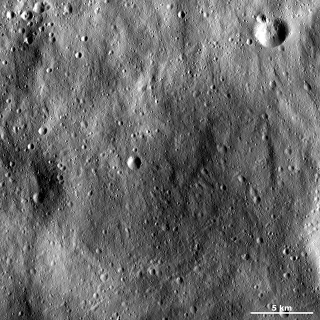 This image of asteroid Vesta from NASA Dawn spacecraft shows an old, very degraded crater that is almost completely filled with regolith. Regolith is the fine-grained material that covers most of Vesta surface.