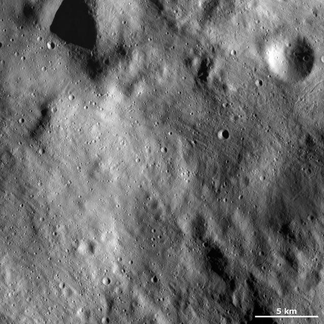 This image of asteroid Vesta from NASA Dawn spacecraft shows a relatively smooth area of Vesta surface. This region is smooth because it is mostly covered by fine-grained debris, known as regolith.