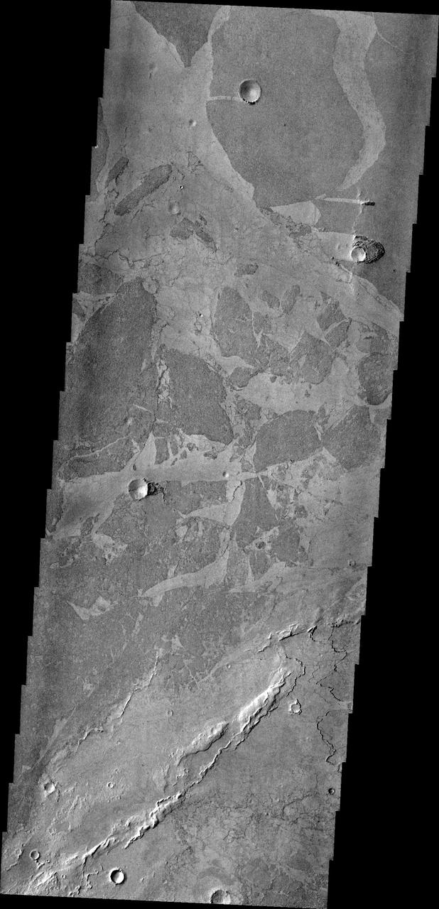 Platy lava flows in Elysium look very different from the thicker flows of the Tharsis region. In this image from NASA 2001 Mars Odyssey spacecraft, the darker plates are separated by lighter material and some edges match-up like puzzle pieces.