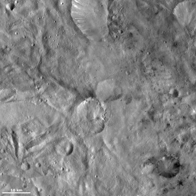 This image from NASA Dawn spacecraft of asteroid Vesta shows Helena crater, which is the crater that resembles the shape of a butterfly wings center, and Laelia crater bottom right.