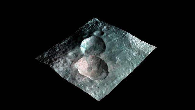 This image from NASA Dawn mission shows a 3-D rendering of the craters that make up the nowman feature on the giant asteroid Vesta. From left to right, the craters are named Marcia, Calpurnia, and Minucia.