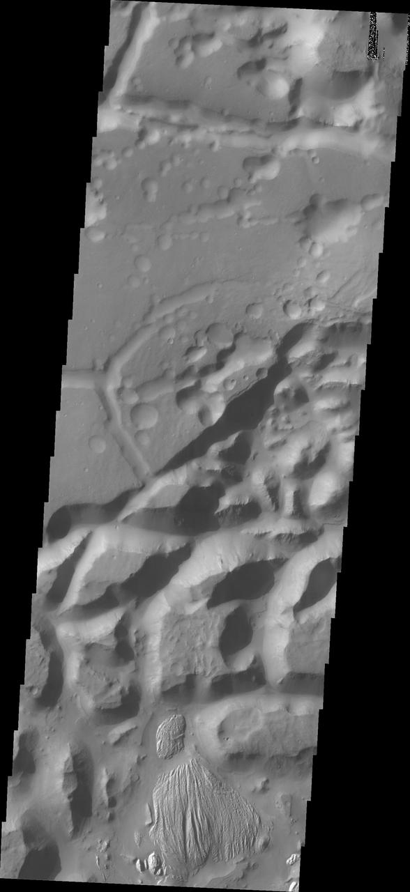 The isolated mesas in this image from NASA 2001 Mars Odyssey spacecraft are part of Arsinoes Chaos. There is a material that differs from the rest of the chaos visible at the bottom of the image.