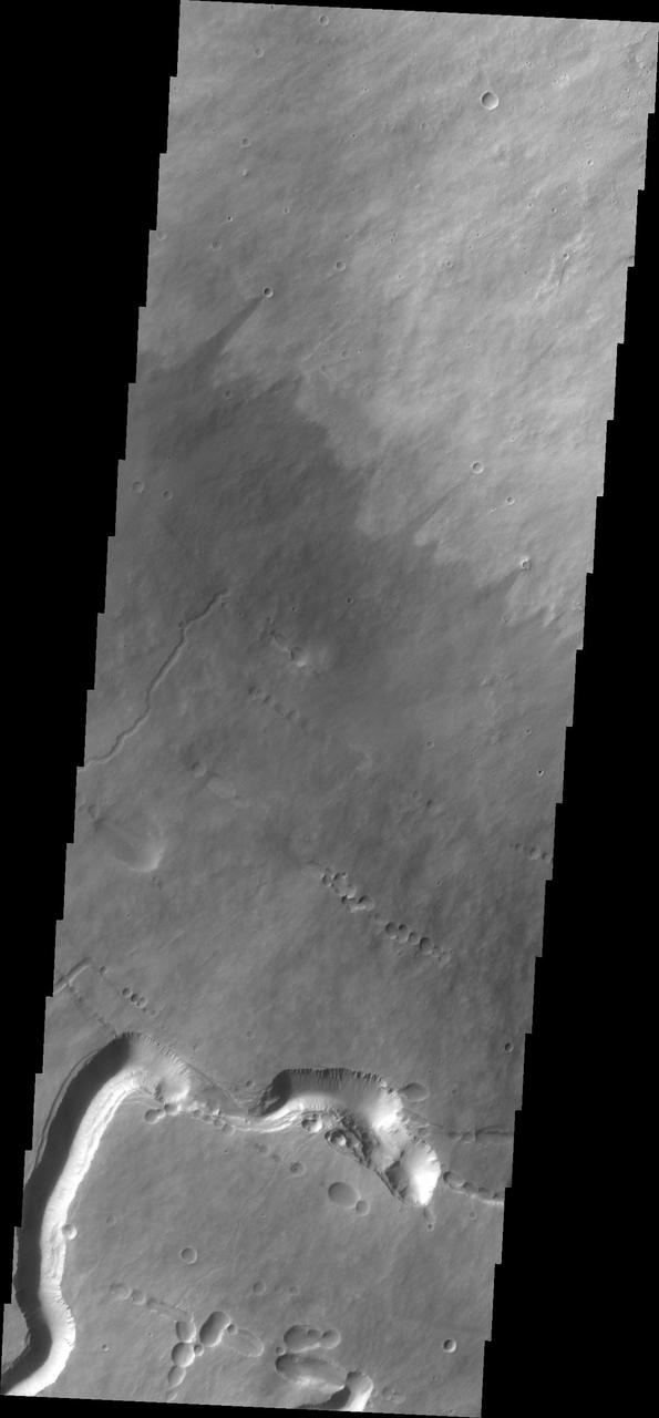 This image captured by NASA 2001 Mars Odyssey spacecraft shows part of the southern flank of Pavonis Mons. Visible at the bottom of the image are collapse features and lava channels.