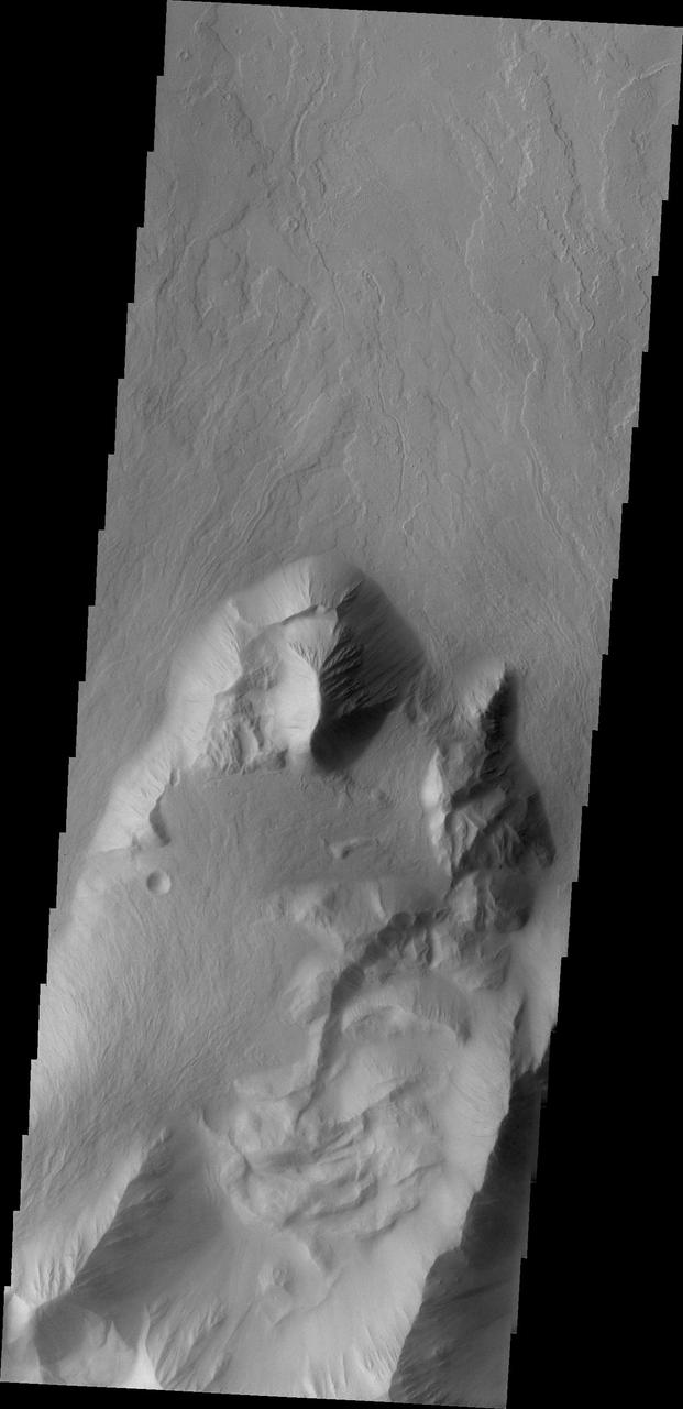 This image from NASA 2001 Mars Odyssey spacecraft shows lava flows which have plunged over the steep escarpment marking the edge of Olympus Mons into the surrounding plains.